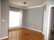 Empty room featuring wood floors, crown molding, a bright window, and neutral gray walls at 3008 River Hill Ln, Burlington, NC 27217