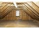 View of unfinished attic space with plywood and exposed rafters, and a small window at 3112 Lake Pointe Trl, Rocky Mount, NC 27804