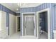 Bathroom features a shower, blue striped wallpaper, and white cabinets at 3112 Lake Pointe Trl, Rocky Mount, NC 27804