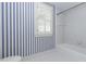 Bathroom features blue striped wallpaper, window with shutters, and a bathtub at 3112 Lake Pointe Trl, Rocky Mount, NC 27804