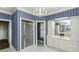 Bathroom features a shower, blue striped wallpaper, chandelier, and white cabinets at 3112 Lake Pointe Trl, Rocky Mount, NC 27804