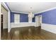 Traditional dining room with hardwood floors, wainscoting and blue walls illuminated by a crystal chandelier at 3112 Lake Pointe Trl, Rocky Mount, NC 27804