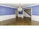 Traditional dining room with dark hardwood floors, wainscoting and blue walls illuminated by an ornate chandelier at 3112 Lake Pointe Trl, Rocky Mount, NC 27804