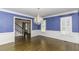 Traditional dining room with dark hardwood floors, wainscoting and blue walls illuminated by an ornate chandelier at 3112 Lake Pointe Trl, Rocky Mount, NC 27804