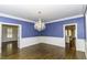 Traditional dining room with dark hardwood floors, wainscoting and blue walls illuminated by an ornate chandelier at 3112 Lake Pointe Trl, Rocky Mount, NC 27804
