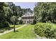 A stately brick home surrounded by trees and manicured greenery sits on a lush green lawn at 3112 Lake Pointe Trl, Rocky Mount, NC 27804