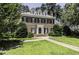 A lush lawn and mature trees surround this stately brick home with dark shutters at 3112 Lake Pointe Trl, Rocky Mount, NC 27804