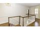 Bright hallway features hardwood floors, white walls, and decorative stairway banister at 3112 Lake Pointe Trl, Rocky Mount, NC 27804