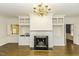 Living room featuring a fireplace, hardwood floors, built-in shelving, a chandelier, and kitchen access at 3112 Lake Pointe Trl, Rocky Mount, NC 27804