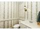 Charming powder room with floral wallpaper and classic fixtures at 3112 Lake Pointe Trl, Rocky Mount, NC 27804