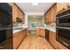 Galley style kitchen with light wood cabinets and black appliances at 3701 Baron Cooper Pass # 303, Raleigh, NC 27612