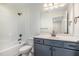 Clean bathroom with a shower-tub combo and dark blue vanity at 407 Kadir Womble Dr, New Hill, NC 27562