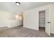 Bright bedroom featuring neutral walls, carpet, and an organized walk-in closet at 407 Kadir Womble Dr, New Hill, NC 27562