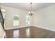 Empty dining room with hardwood floors and large windows that fill the space with light at 407 Kadir Womble Dr, New Hill, NC 27562