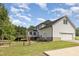 Rear exterior of home shows a garage, fenced in yard, patio, and deck at 407 Kadir Womble Dr, New Hill, NC 27562