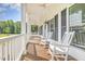 Inviting front porch with rocking chairs, ceiling fans, and white pillars at 407 Kadir Womble Dr, New Hill, NC 27562