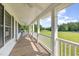 Spacious front porch with white railing offering scenic views of the landscaped yard at 407 Kadir Womble Dr, New Hill, NC 27562