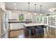 Modern kitchen with stainless steel appliances, large island with bar stools, and hardwood floors at 407 Kadir Womble Dr, New Hill, NC 27562