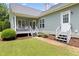 Backyard with a covered porch, a well-maintained lawn, and mature landscaping at 4111 Branchwood Dr, Durham, NC 27705
