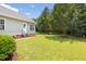 Spacious backyard with green lawn, mature trees, and landscaping, offering privacy at 4111 Branchwood Dr, Durham, NC 27705