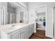 Bathroom featuring double sinks, white cabinets, and a view into the bedroom at 4111 Branchwood Dr, Durham, NC 27705