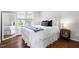 Bedroom with a bed, side table, mirror, and a window providing natural light at 4111 Branchwood Dr, Durham, NC 27705