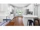 Modern white kitchen featuring stainless steel appliances, a large bay window, and hardwood flooring at 4111 Branchwood Dr, Durham, NC 27705