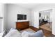 Cozy living room with hardwood floors, large TV, and open doorway to sitting area at 4111 Branchwood Dr, Durham, NC 27705