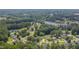 A scenic aerial view shows a neighborhood with trees, nearby lake, and bridges, set against a backdrop of lush forest at 4140 Willow Haven Ct, Raleigh, NC 27616
