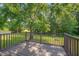 Relax on the wooden back deck, offering a serene view of the lush backyard and mature trees at 4140 Willow Haven Ct, Raleigh, NC 27616