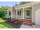 Inviting front porch with a charming white railing and landscaped flower bed at 4140 Willow Haven Ct, Raleigh, NC 27616