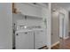 Convenient laundry room features full-size washer and dryer, along with upper shelving for storage solutions at 4140 Willow Haven Ct, Raleigh, NC 27616