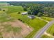 Aerial view of a home surrounded by green fields, trees, and a white fence, creating a peaceful landscape at 419 Mabry Rd, Angier, NC 27501