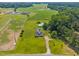 Expansive aerial view of home and surrounding acreage, featuring lush green fields and distant buildings at 419 Mabry Rd, Angier, NC 27501