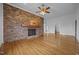 Sunlit living room featuring a brick fireplace and hardwood floors with open doorway at 419 Mabry Rd, Angier, NC 27501