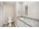 Bathroom featuring granite countertop, white vanity with sink and modern fixtures at 4403 Sunburst Ct, Raleigh, NC 27613