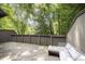 Outdoor wooden deck features comfortable seating, surrounded by privacy fencing and mature trees at 4403 Sunburst Ct, Raleigh, NC 27613