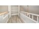 Upstairs hallway featuring wood floors, shelving and a view of a ceiling fan at 4403 Sunburst Ct, Raleigh, NC 27613