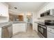 Bright kitchen features stainless steel appliances, white cabinets, and views to other living areas at 4403 Sunburst Ct, Raleigh, NC 27613
