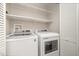 Laundry room boasts a washer and dryer with overhead shelving and added storage space at 4403 Sunburst Ct, Raleigh, NC 27613