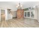 Open living room with brick fireplace, wood-look floors, and natural light at 4403 Sunburst Ct, Raleigh, NC 27613