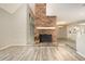 Open living room with brick fireplace, wood-look floors, and natural light at 4403 Sunburst Ct, Raleigh, NC 27613