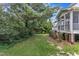 This backyard features a lush green lawn, mature trees, and access to the home's screened porch at 500 Chandler Grant Dr, Cary, NC 27519