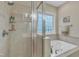 A luxurious bathroom boasts a soaking tub, a glass-enclosed shower, and tiled walls at 500 Chandler Grant Dr, Cary, NC 27519