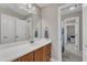 Bathroom featuring a wood vanity with white countertop, a large mirror, and a view of the tiled floor at 500 Chandler Grant Dr, Cary, NC 27519