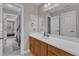 Bathroom with a white countertop, wood cabinets, and a large mirror reflecting the bedroom through the doorway at 500 Chandler Grant Dr, Cary, NC 27519