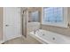 A serene bathroom offers a soaking tub, a glass-enclosed shower, and ample natural light at 500 Chandler Grant Dr, Cary, NC 27519