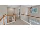 Upstairs hallway with wooden railing, a hanging chandelier and natural light coming through the window at 500 Chandler Grant Dr, Cary, NC 27519