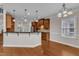 Bright kitchen with wood cabinets, granite counters, and pendant lighting over breakfast bar at 500 Chandler Grant Dr, Cary, NC 27519