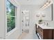 Bright bathroom featuring black and white tile, a vanity sink, and a window view to trees at 508 Bolin Creek Dr, Carrboro, NC 27510